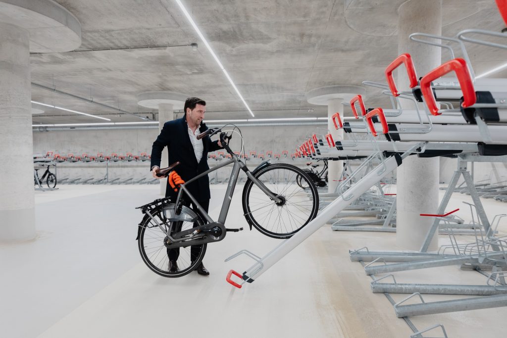 man zet fiets weg in ondergrondse fietsenstalling