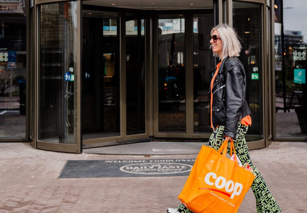 vrouw met Coop-tas loopt langs de Daily Taste